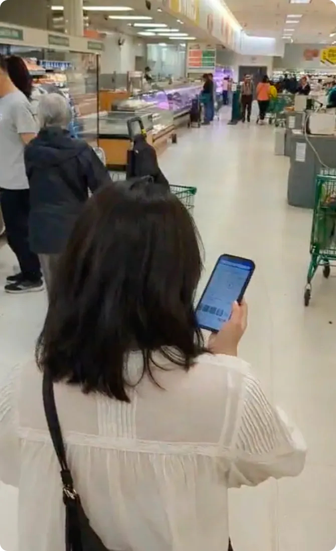 Participant using the Store Map app on a phone while shopping in a grocery store aisle